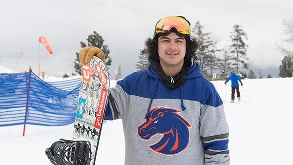 A snowboarder in Boise State attire